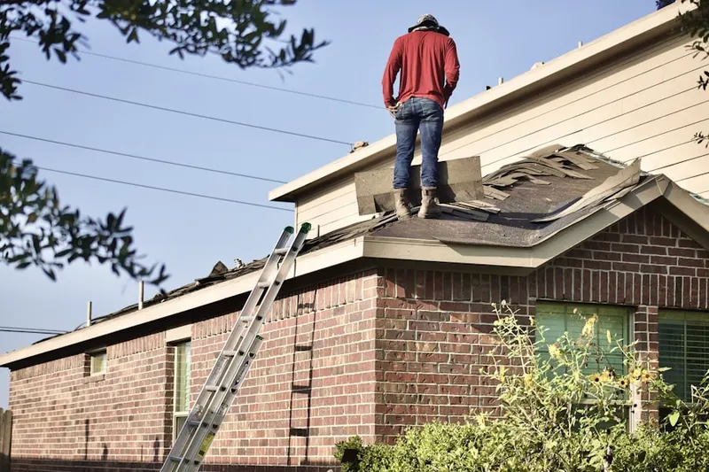 Professional roofer working on a residential roof in East Setauket